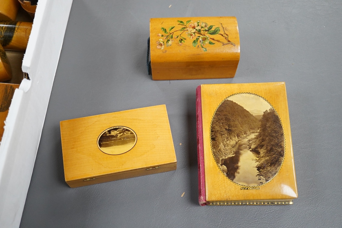 A collection of Scottish mauchline ware boxes, a pin cushion, beaker and a photo frame containing black and white topographical photos